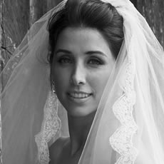 Portrait de mariée en noir et blanc en gros plan, mettant en valeur le voile, les détails en dentelle et l'expression de la mariée